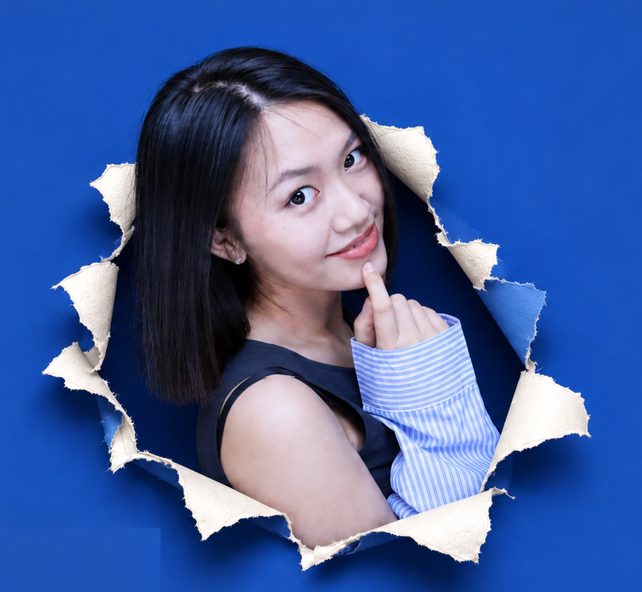 Wenbei Li emerging through torn blue paper